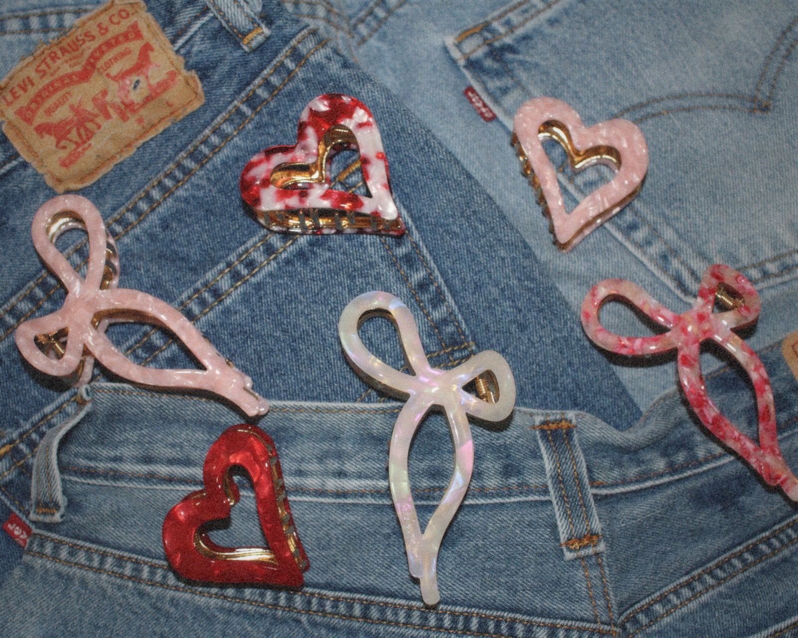 Decorative heart and bow hair clips on a denim background