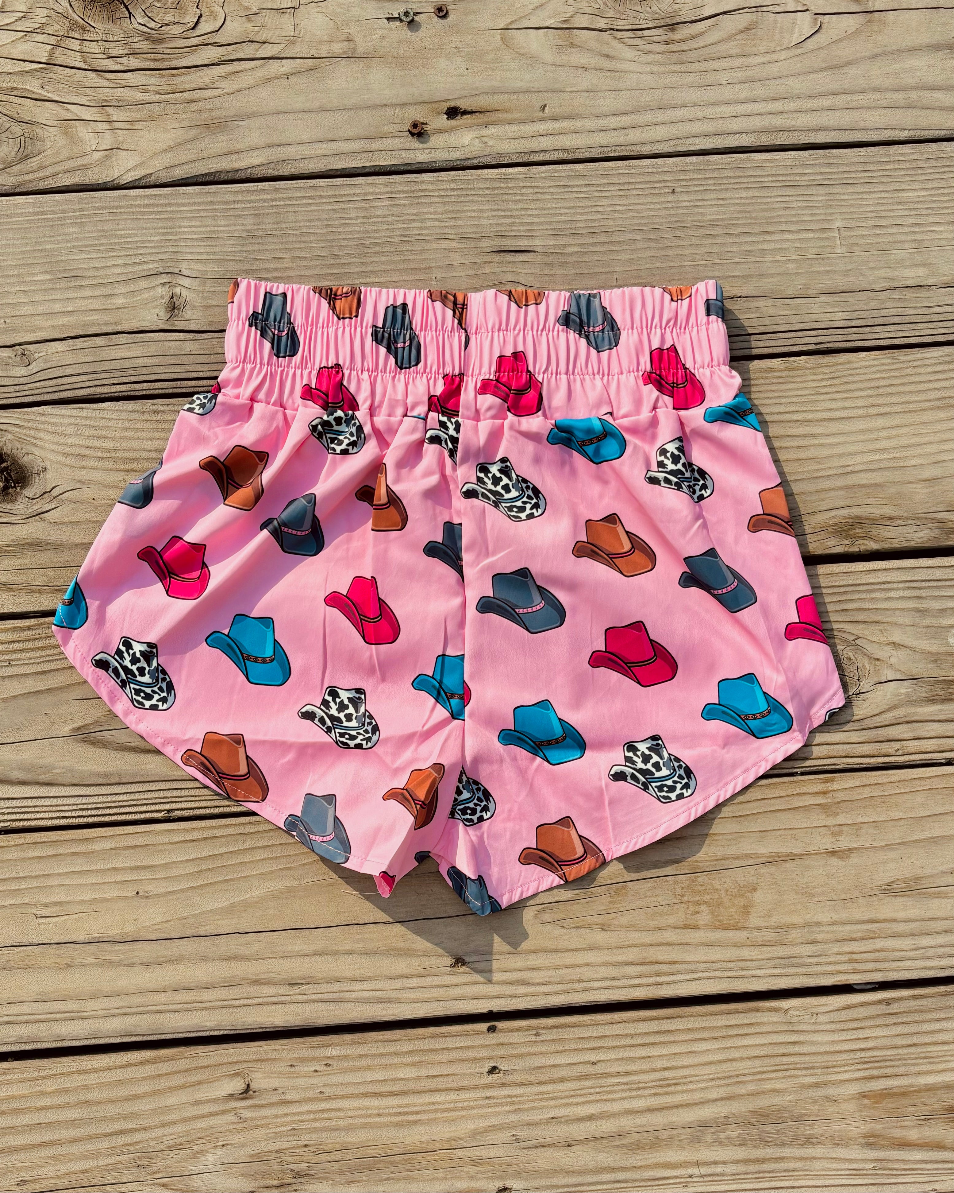Pink athletic shorts with colorful cowboy hat print western casual women’s outfit