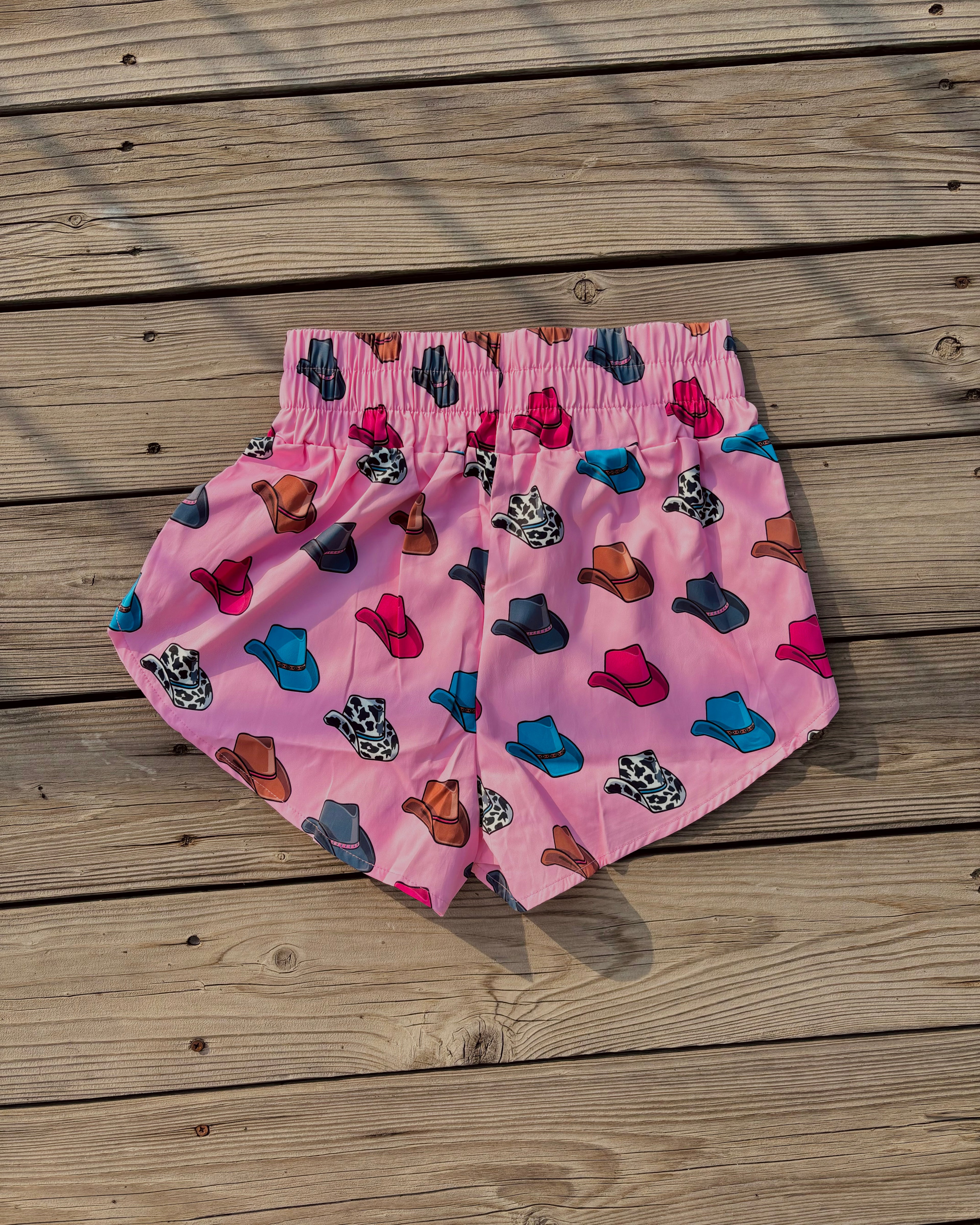 Pink athletic shorts with colorful cowboy hat print western casual women’s outfit