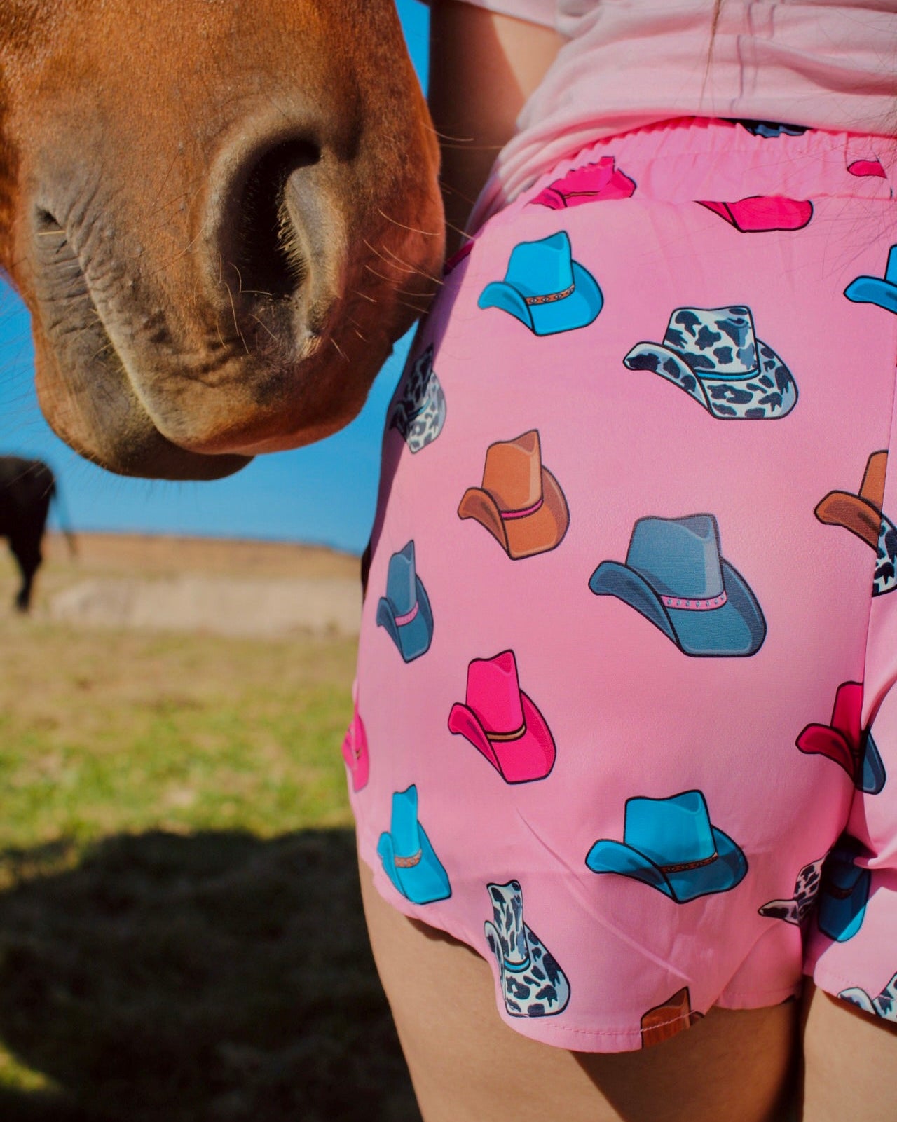 Pink athletic shorts with colorful cowboy hat print western casual women’s outfit